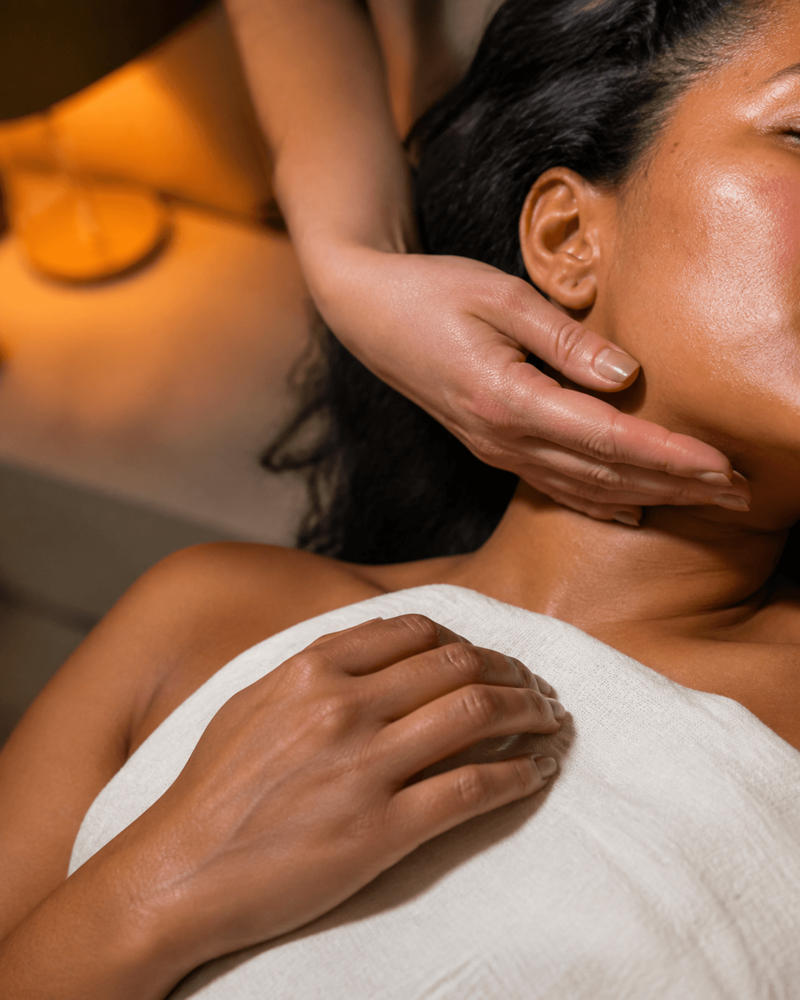 A hand supports an anonymous jaw during a warm-lit treatment moment